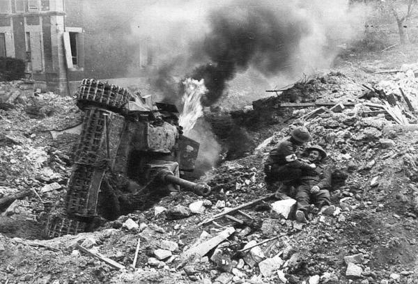 A Canadian medic is rescuing a buddy near a burning Sturmgeschütz III. Somewhere north of Falaise, France ca. August 1944