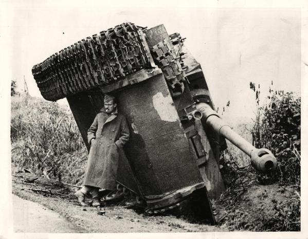 British soldier protecting himself from the rain under turned over tank, Italy, 1944