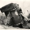 British soldier protecting himself from the rain under turned over tank, Italy, 1944