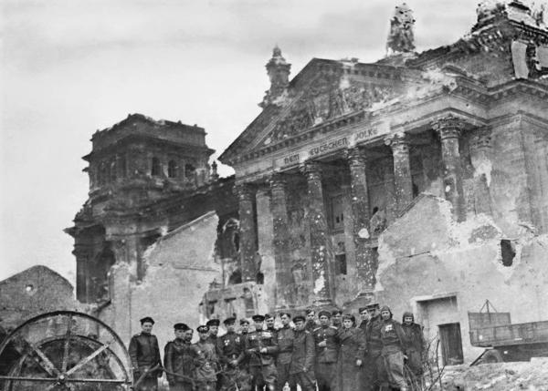 Red Army soldiers pose in front of the Reichstag 1945