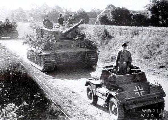 A captured British Dingo armored car leading a column of Tiger Is