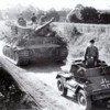 A captured British Dingo armored car leading a column of Tiger Is