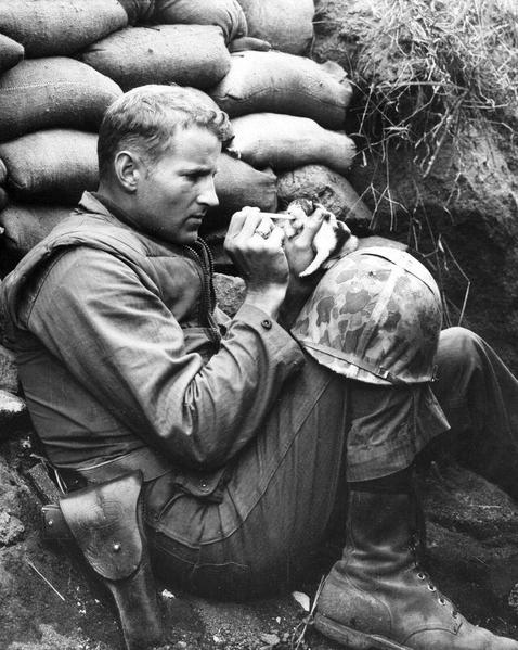 US Marine feeds an orphan kitten found after a heavy mortar barrage near Bunker Hill, Korean War, 1953