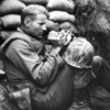 US Marine feeds an orphan kitten found after a heavy mortar barrage near Bunker Hill, Korean War, 1953