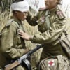 Wounded Russian, child soldier, is patched up by a child medic in the field