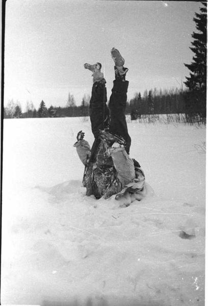 The frozen corpse of a German soldier is used as an impromptu street sign near the front line, Eastern Front, 1942